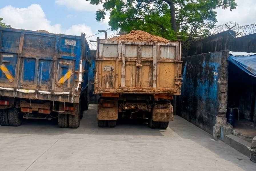 Two loaded trucks lined up in the yard